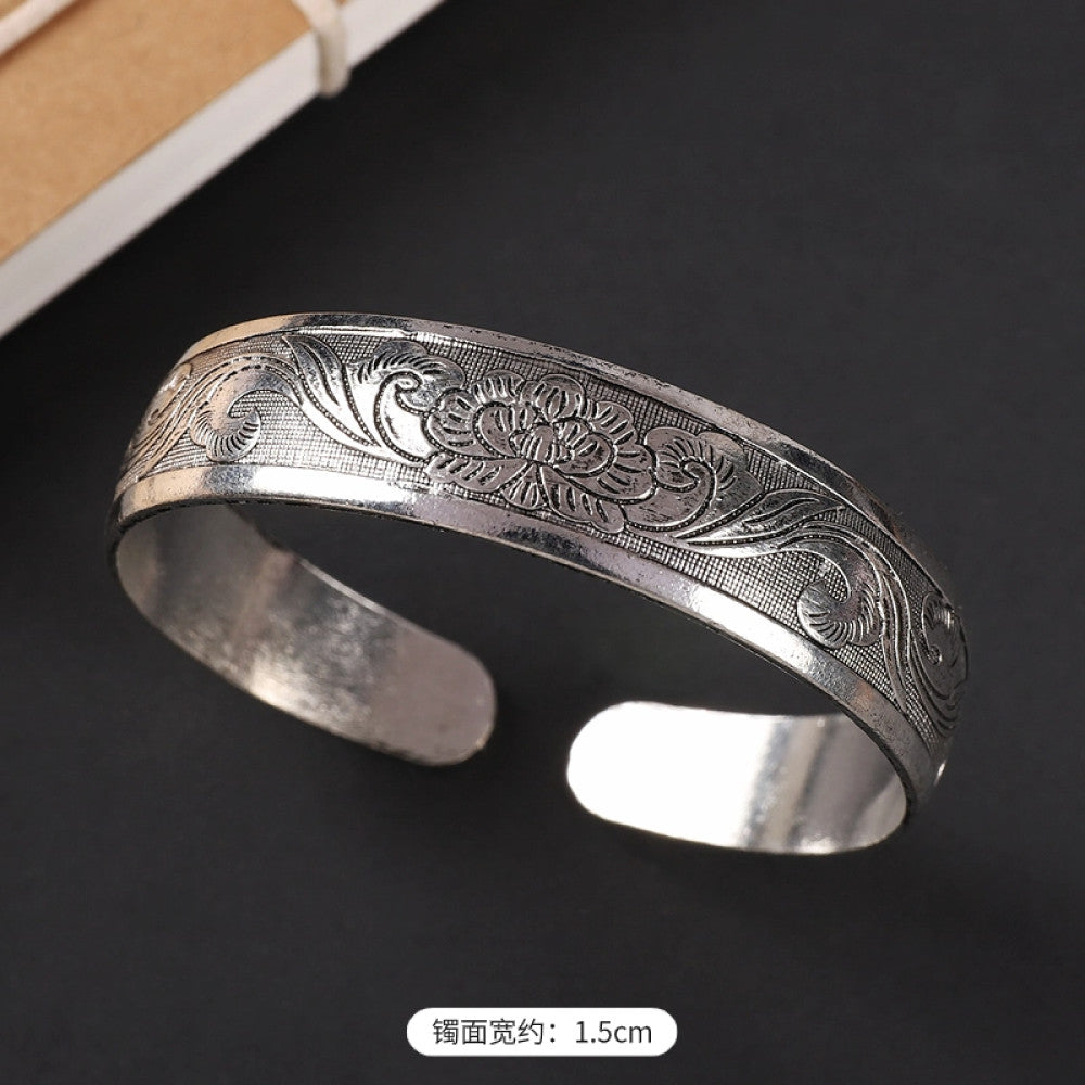 Vintage boho chic silver-tone filigree cuff bracelet with intricate floral designs, styled on a black surface, perfect for bohemian and ethnic fashion lovers in the US 01