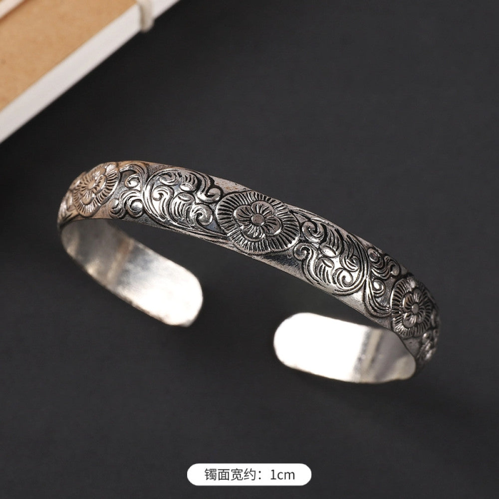 Vintage boho chic silver-tone filigree cuff bracelet with intricate floral designs, styled on a black surface, perfect for bohemian and ethnic fashion lovers in the US 04