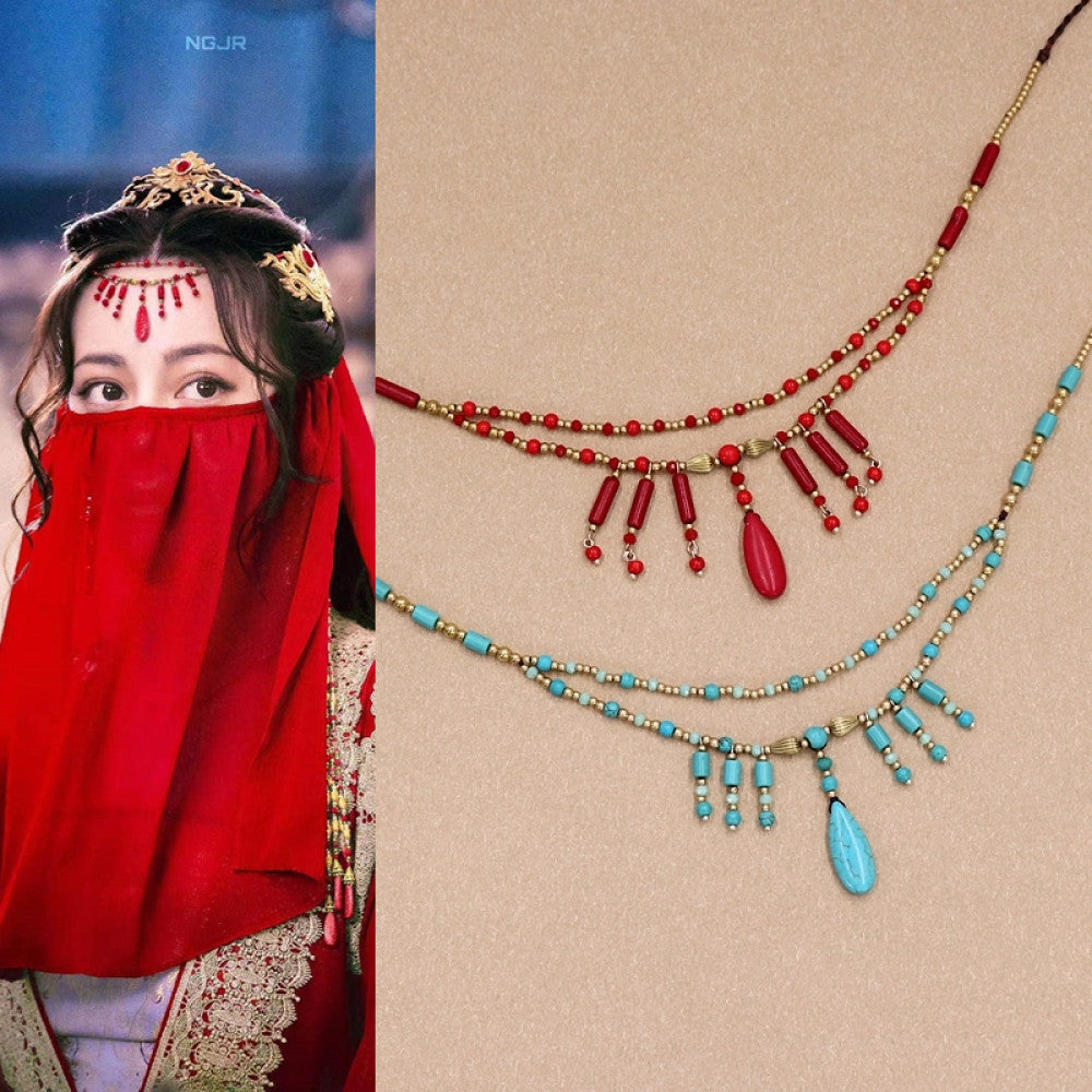 Boho vintage ethnic 2-piece forehead chain (face veil) ornaments (in red & turquoise bead styles) with tassel pendants, displayed on a beige surface