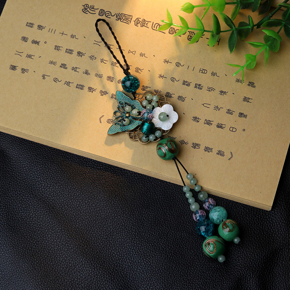 This butterfly and flower glass tassel pendant combines butterfly and flower designs with handmade glass craftsmanship, accented with light tassels, showcasing a feminine and graceful presence. 05