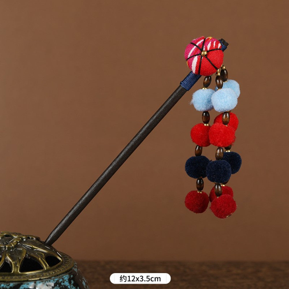 Boho vintage ethnic hair stick pendant featuring colorful pom poms, multi-color beaded accents, and a long orange tassel, displayed alongside an incense burner on a wooden surface against a brown background, ideal for bohemian and traditional fashion enthusiasts in the US 03