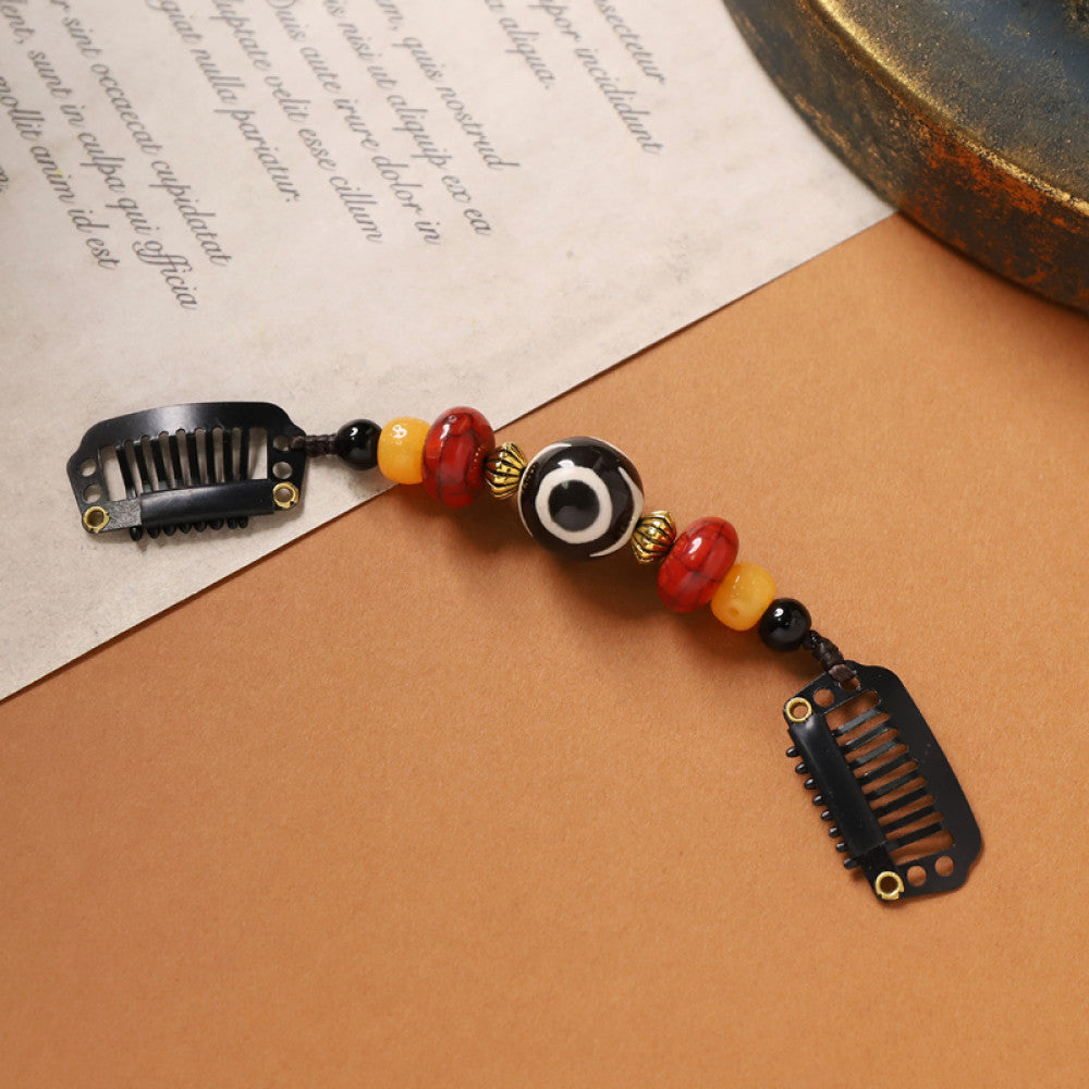 Boho vintage ethnic double hair comb ornament (displayed on a beige surface & text-printed paper background) featuring an evil eye decorative bead, red/yellow beads, and black hair combs, ideal for bohemian retro fashion styling in the US
