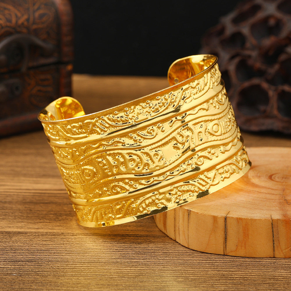 Boho vintage ethnic engraved gold cuff bangle with geometric designs, styled on wooden surface, ideal for bohemian and tribal fashion enthusiasts 09