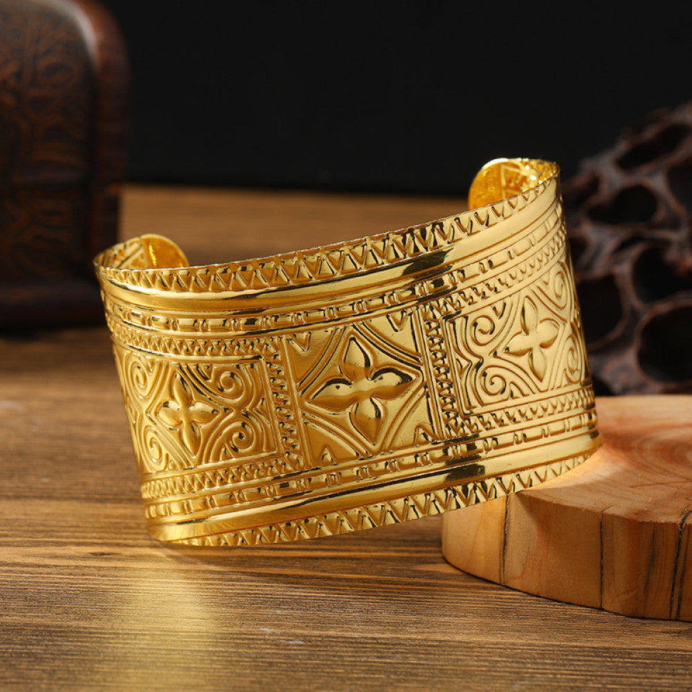 Boho vintage ethnic engraved gold cuff bangle with geometric designs, styled on wooden surface, ideal for bohemian and tribal fashion enthusiasts 14
