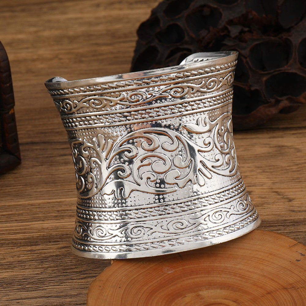 Boho vintage ethnic engraved silver cuff bangle with intricate floral designs, styled on wooden surface, ideal for bohemian and tribal fashion enthusiasts in the US