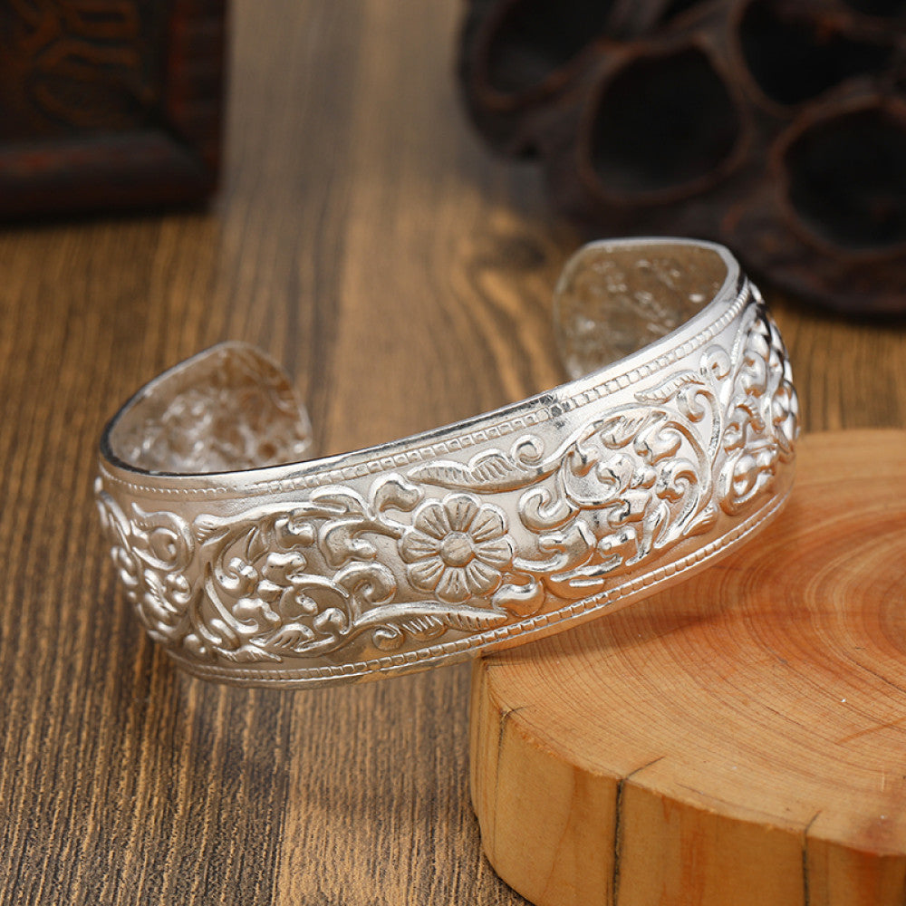 Boho vintage ethnic engraved silver cuff bangle with intricate floral designs, styled on wooden surface, ideal for bohemian and tribal fashion enthusiasts in the US 02