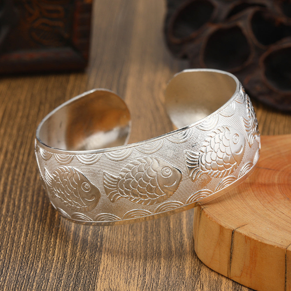 Boho vintage ethnic silver cuff bangle with tribal geometric engravings, styled on wooden surface, perfect for bohemian and tribal fashion lovers in the US 09