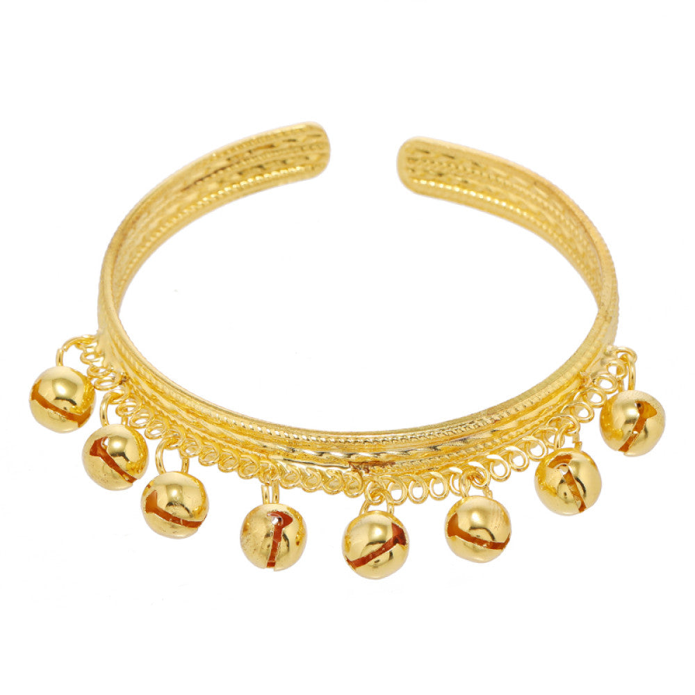 Boho vintage ethnic gold cuff bangle with bell charms, styled on a vintage book, ideal for bohemian and ethnic fashion enthusiasts in the US 02