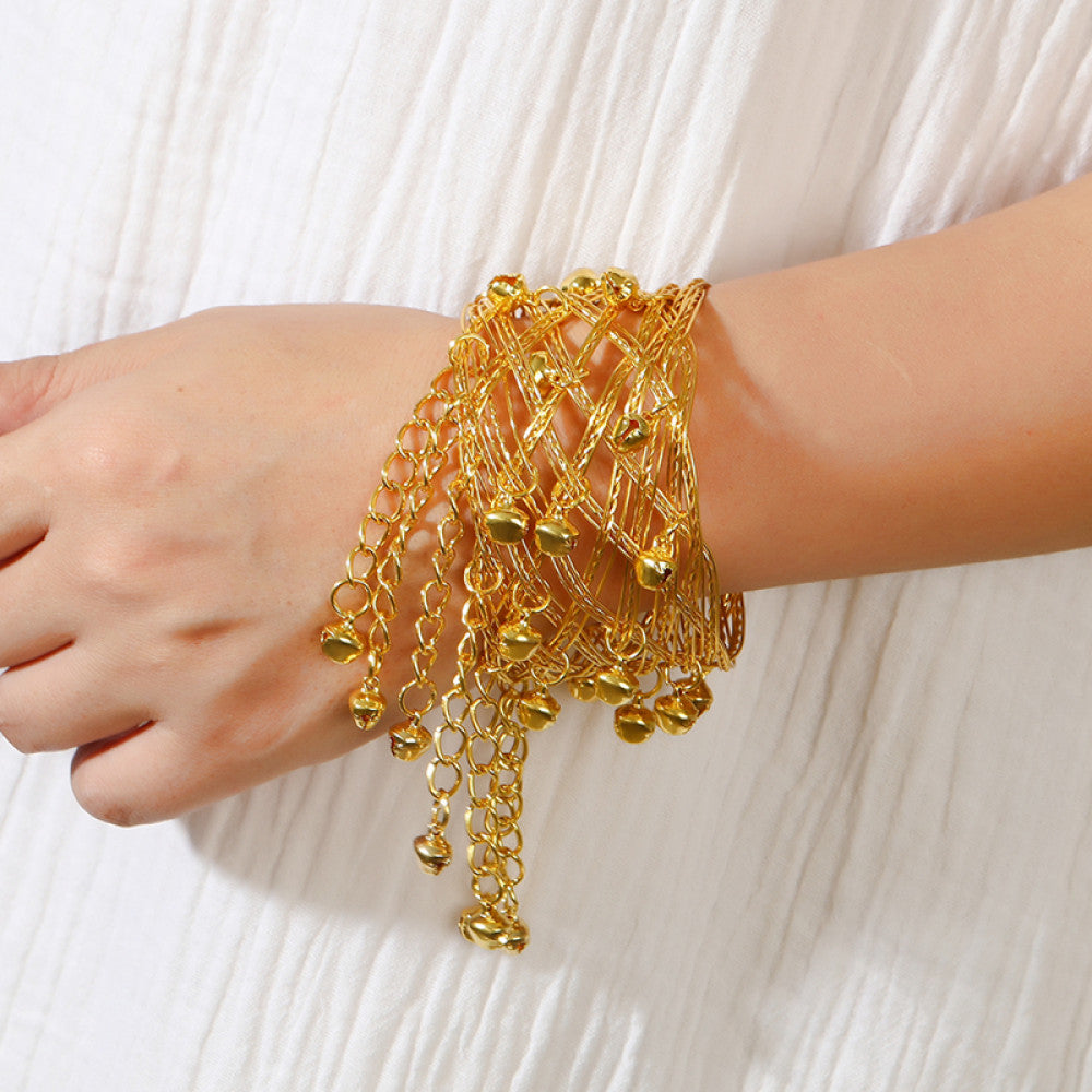Boho vintage ethnic gold cuff bangle with bell and tassel details, styled on a vintage book, ideal for bohemian and ethnic fashion enthusiasts 01