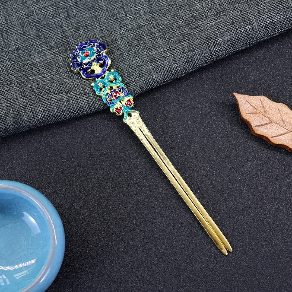 Boho vintage ethnic gold-tone double hair stick featuring vibrant enamel decor (blue/green/red tones) and gemstone accents, displayed on a dark fabric background (paired with a blue ceramic bowl & wooden leaf decor), ideal for bohemian and traditional fashion enthusiasts in the US