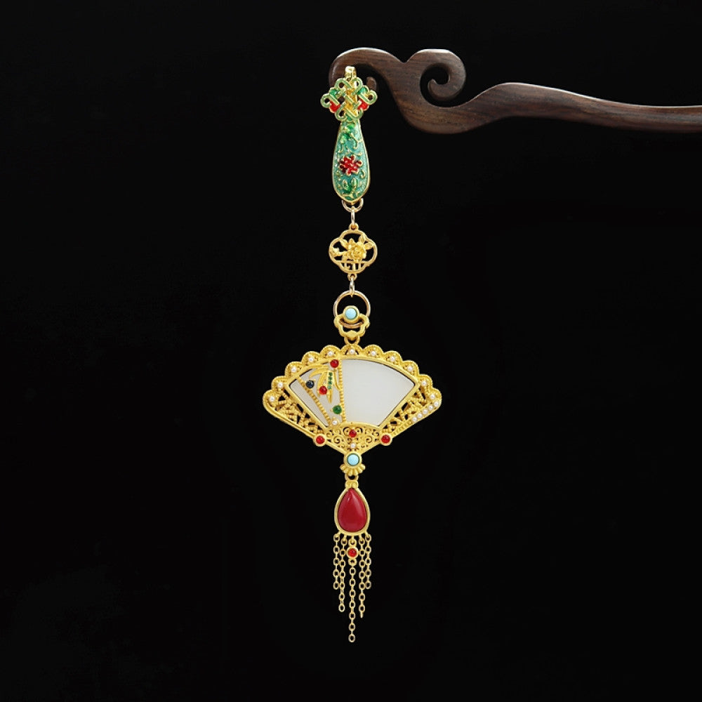 Boho vintage ethnic gold-tone hair pendant featuring green enamel detail, fan-shaped white shell charm, red gemstone accents and delicate tassel, styled on a wooden display hook, ideal for bohemian and traditional fashion enthusiasts in the US