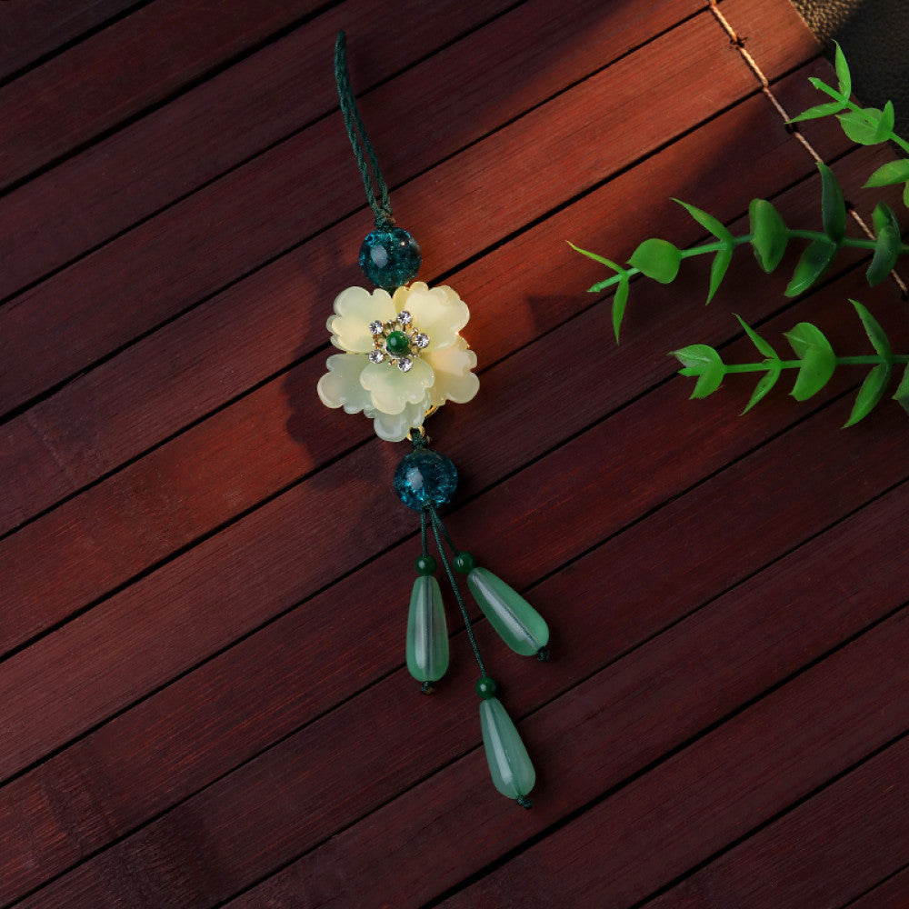 Boho vintage ethnic green-tone hair pendant featuring green cord, dark teal decorative beads, white flower charm (with gemstone center), and light green teardrop pendants, styled against a black fabric background, ideal for bohemian and traditional fashion enthusiasts in the US 05