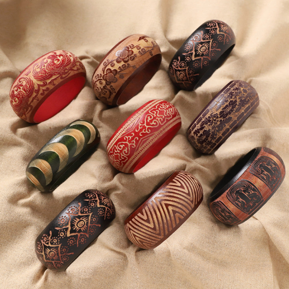 Assorted boho vintage ethnic wood bangle set with carved tribal, floral, geometric designs, styled on burlap surface, ideal for bohemian and tribal fashion enthusiasts in the US