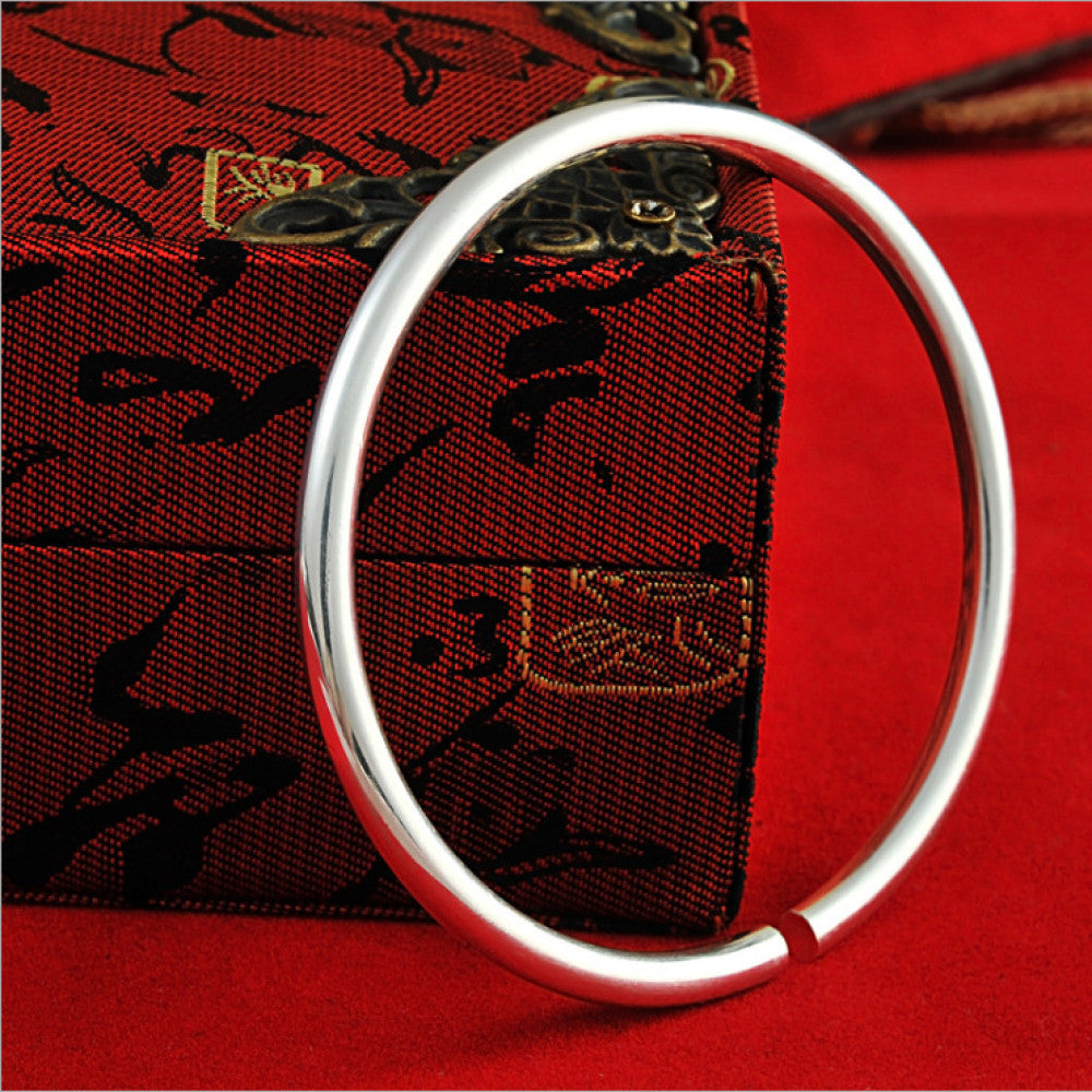 Boho vintage ethnic polished silver bangle, styled with traditional red and black decor, ideal for bohemian and minimalist fashion enthusiasts in the US