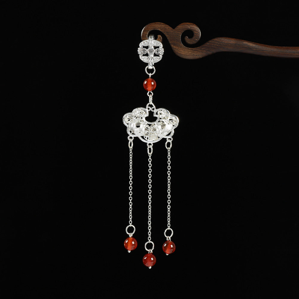 Boho vintage ethnic silver hair pendant with Chinese knot detail, intricate lock charm and red bead tassels, styled on a wooden display hook, ideal for bohemian and traditional fashion enthusiasts in the US