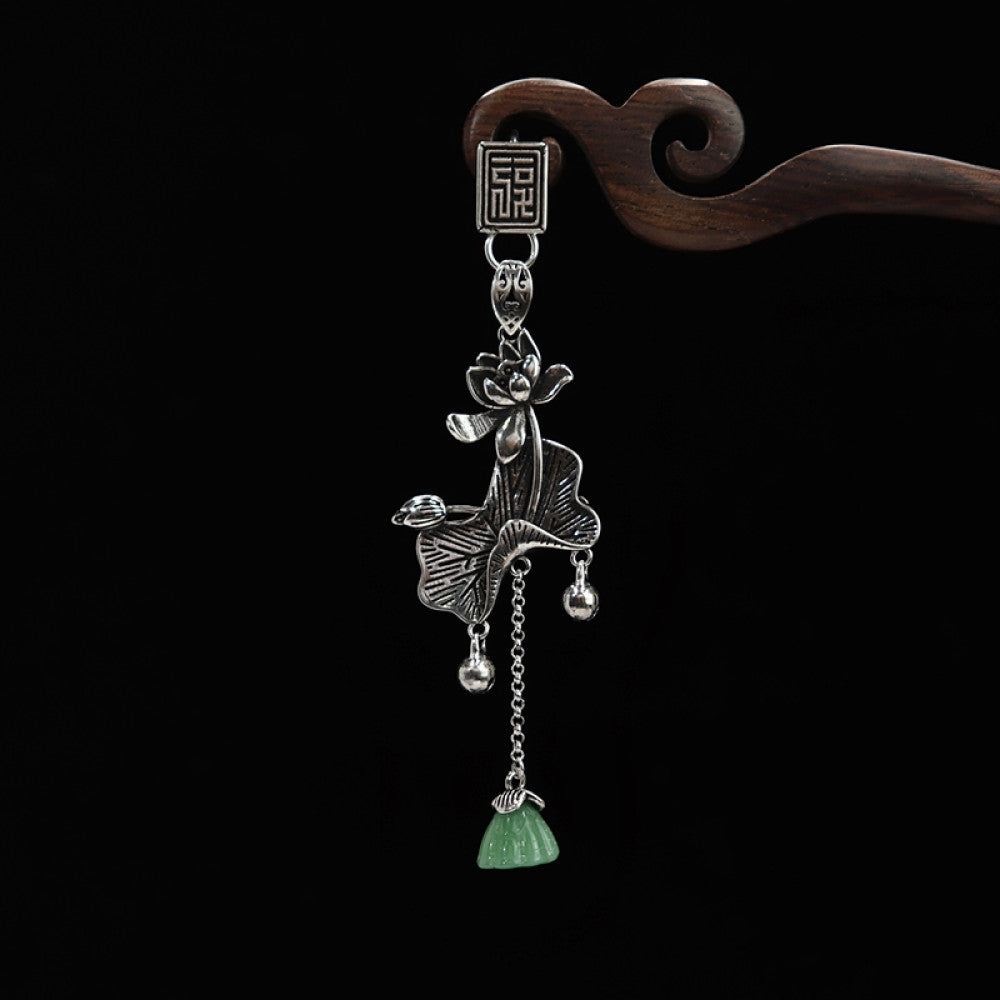 Boho vintage ethnic silver hair pendant featuring fu character detail, opera character-shaped charm and green tassel, styled on a wooden display hook, ideal for bohemian and traditional fashion enthusiasts in the US