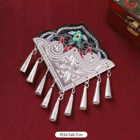 Boho vintage ethnic silver-tone decorative ornament featuring intricate silver-tone detailing, embroidered accent and multiple bell tassel pendants, displayed on a red fabric background