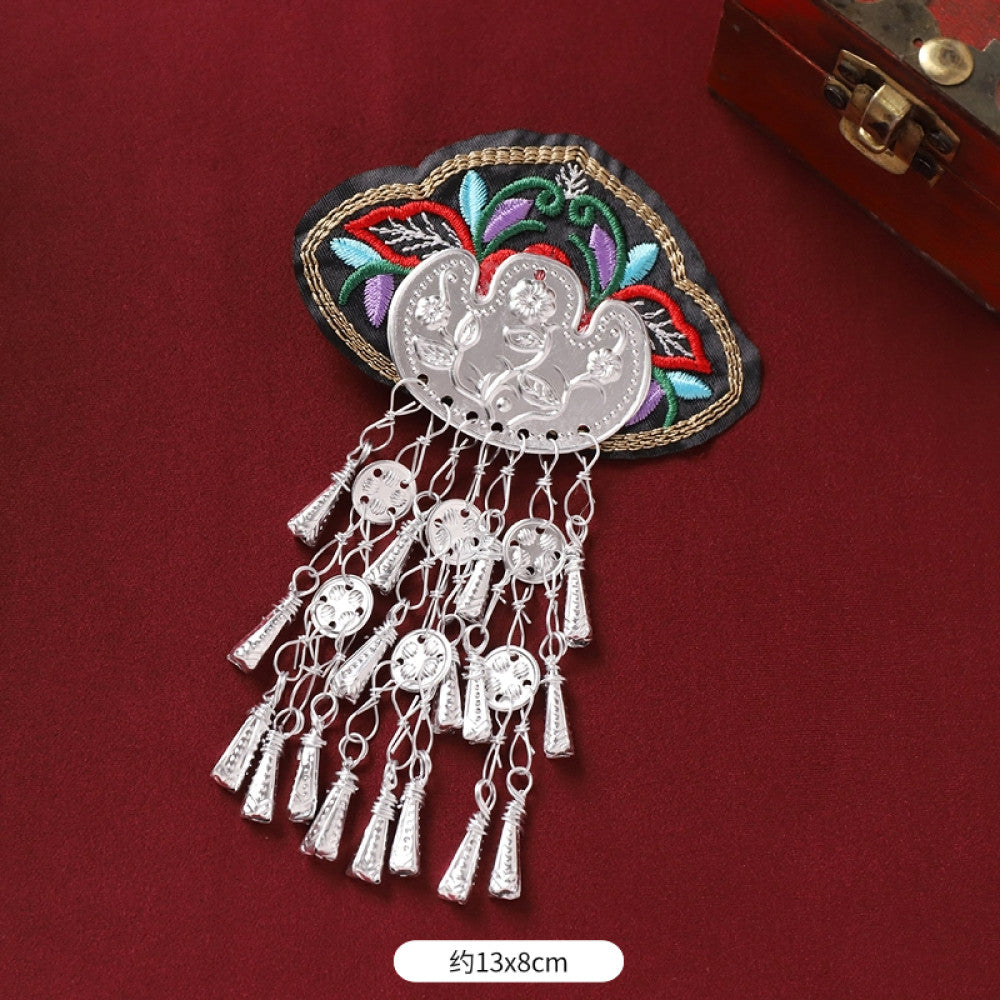 Boho vintage ethnic silver-tone decorative ornament featuring intricate silver-tone detailing, embroidered accent and multiple bell tassel pendants, displayed on a red fabric background 09