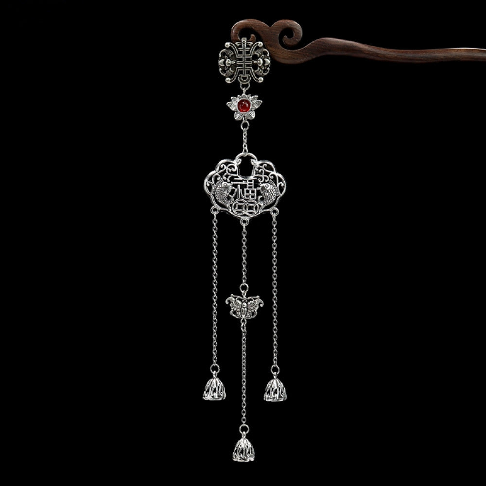 Boho vintage ethnic silver-tone hair pendant featuring Chinese knot charm, red gemstone accent, intricate openwork lock-shaped pendant and layered silver tassels, styled on a wooden display hook against a black background, ideal for bohemian and traditional fashion enthusiasts in the US