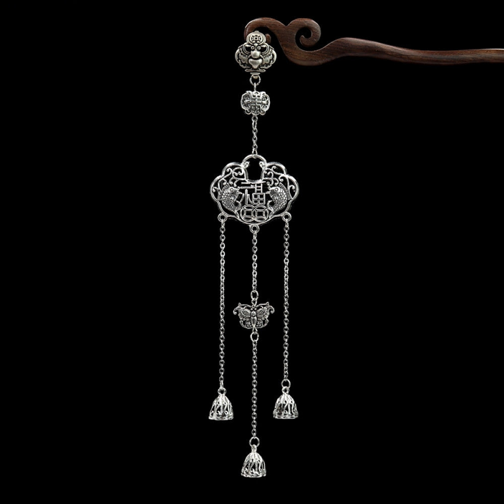Boho vintage ethnic silver-tone hair pendant featuring Chinese knot charm, red gemstone accent, intricate openwork lock-shaped pendant and layered silver tassels, styled on a wooden display hook against a black background, ideal for bohemian and traditional fashion enthusiasts in the US 01
