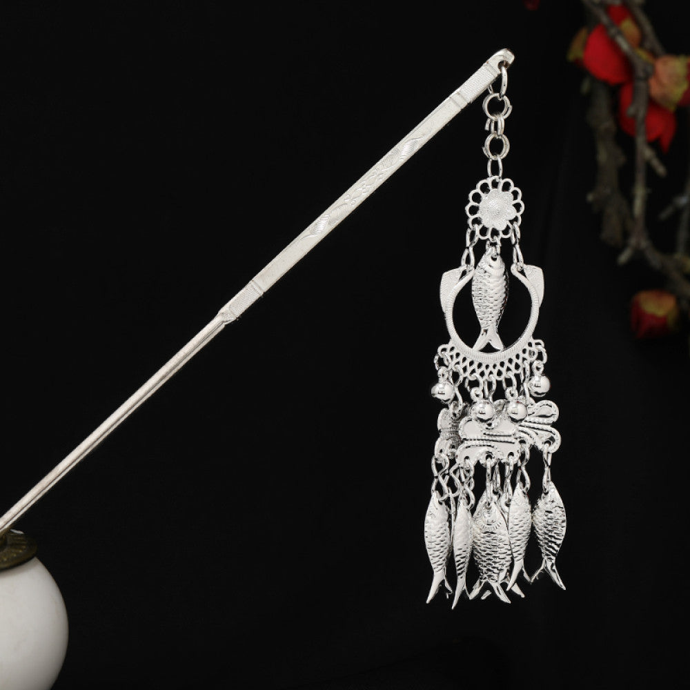 Boho vintage ethnic silver-tone hair stick featuring detailed textured handle, intricate chain network decor, and layered silver tassel pendants, displayed against a black background with red floral accents