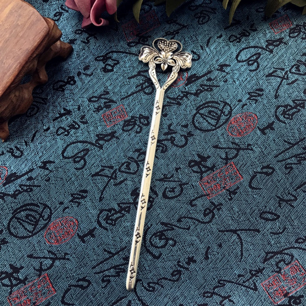 Boho vintage ethnic silver-tone hair stick featuring an intricate curved decorative top, displayed on a blue fabric with text patterns 03