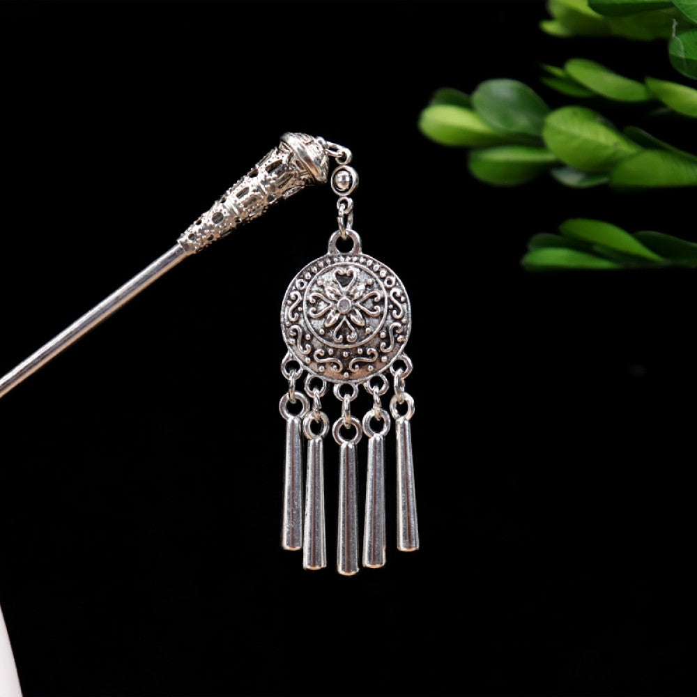 Boho vintage ethnic silver-tone hair stick featuring turquoise beads, an intricate round decorative element, and layered chain tassel fringe, displayed beside a white vessel green foliage , ideal for bohemian and traditional fashion enthusiasts in the US 02