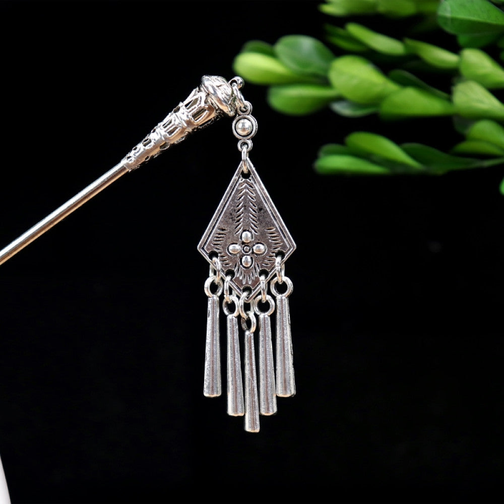 Boho vintage ethnic silver-tone hair stick featuring turquoise beads, an intricate round decorative element, and layered chain tassel fringe, displayed beside a white vessel green foliage , ideal for bohemian and traditional fashion enthusiasts in the US 04