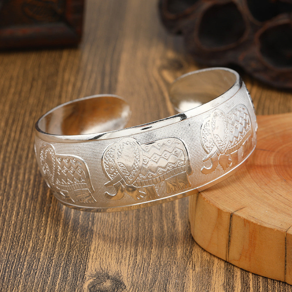 Boho vintage ethnic silver cuff bangle with tribal geometric engravings, styled on wooden surface, perfect for bohemian and tribal fashion lovers in the US 01