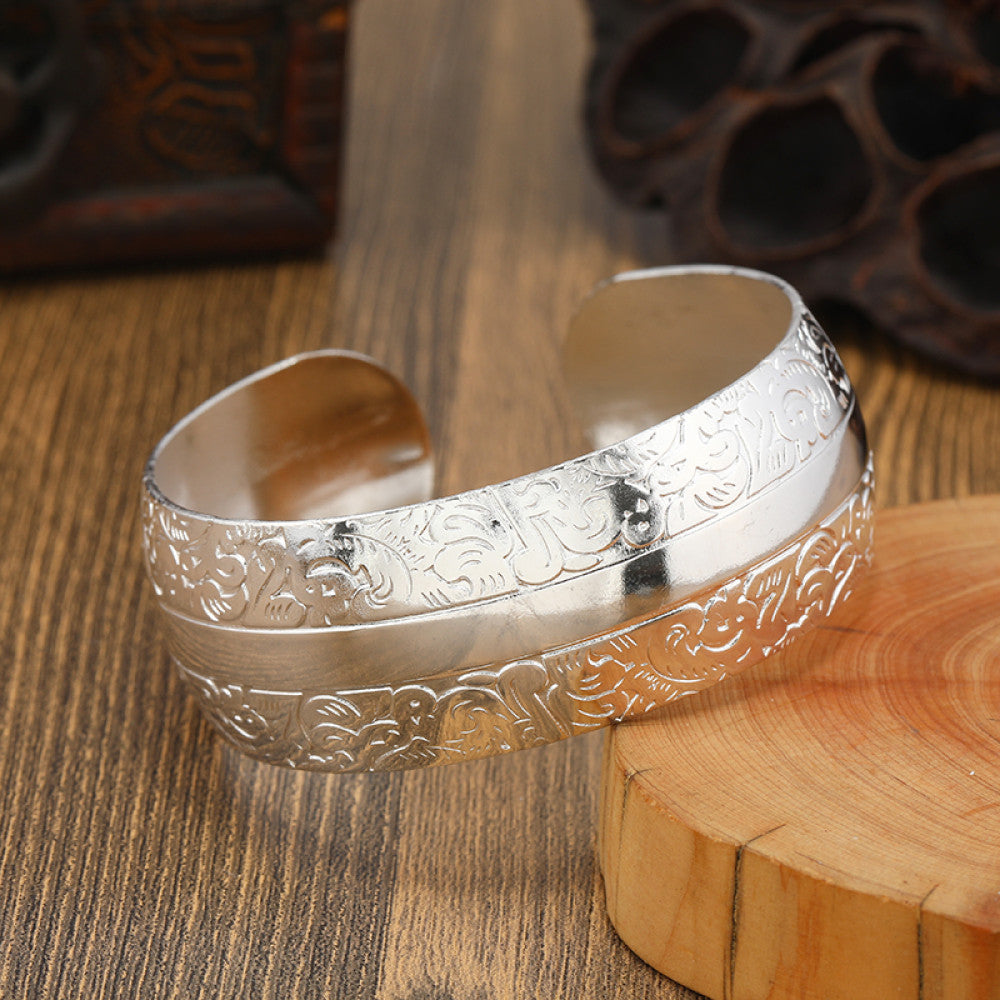 Boho vintage ethnic silver cuff bangle with tribal geometric engravings, styled on wooden surface, perfect for bohemian and tribal fashion lovers in the US 05