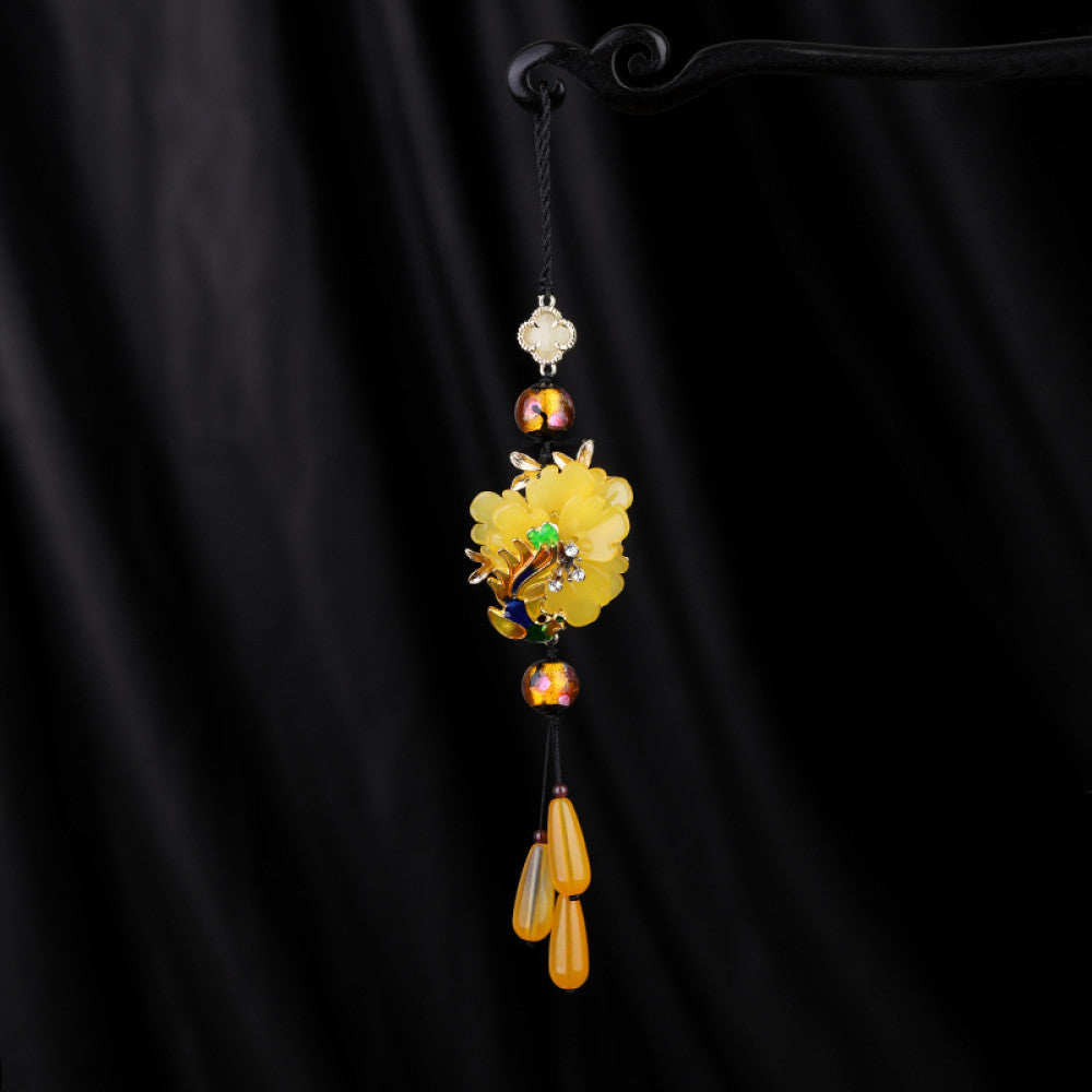 Boho vintage ethnic yellow-tone hair pendant featuring black cord, yellow flower-shaped charm (with multi-color gemstone & gold accents), and yellow teardrop pendants, styled against a black fabric background, ideal for bohemian and traditional fashion enthusiasts in the US