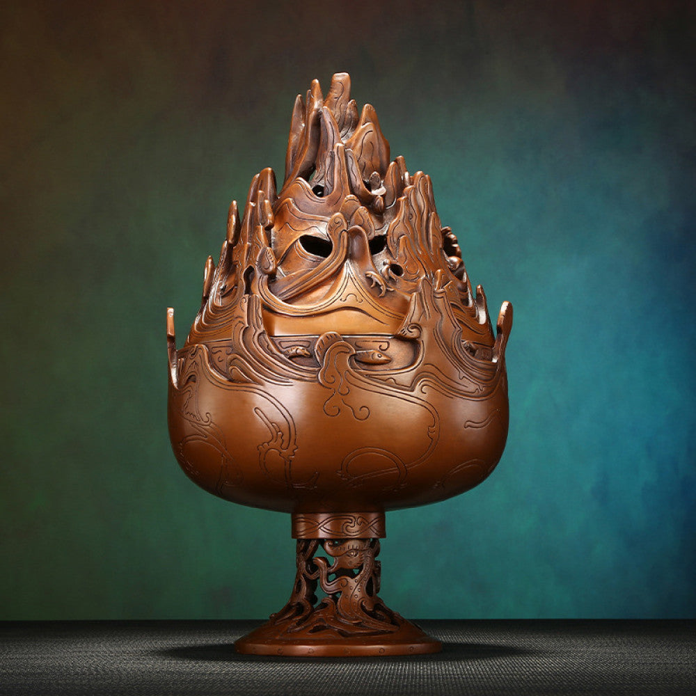 Intricate bronze Boshan-style Chinese incense burner with mountain-shaped pierced lid and dragon motifs, a Feng Shui symbol of wealth and elegance, displayed as a sophisticated home decor piece against a teal textured background