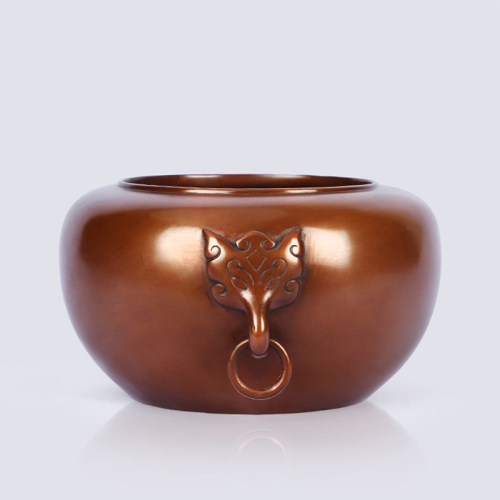 Polished bronze Chinese censer with intricate beast-head handle and ring, a Feng Shui symbol of wealth and harmony, displayed as elegant home decor against a light background 01