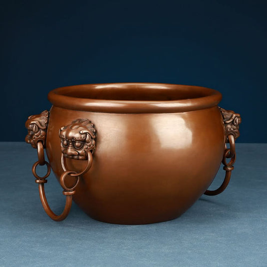 Polished bronze Chinese decorative vessel with intricate beast-head handles and hanging rings, a Feng Shui symbol of wealth and protection, displayed as elegant home decor against a white background 01