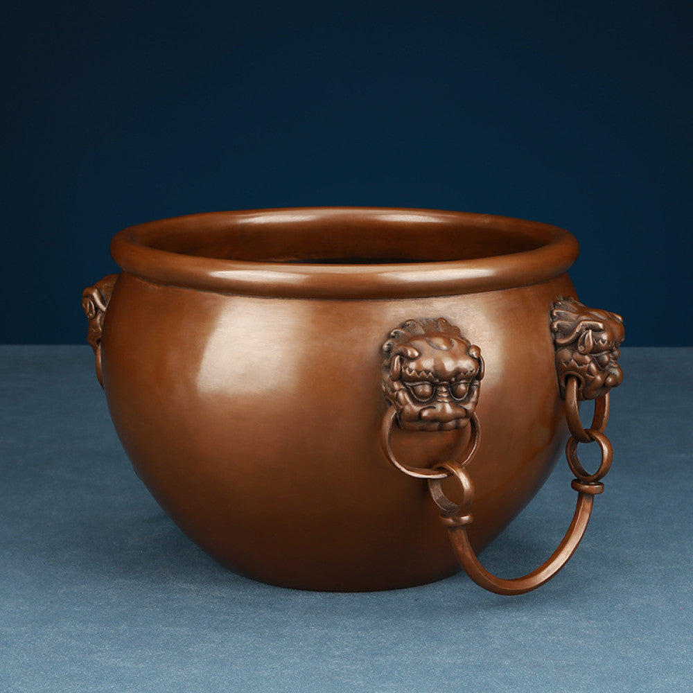 Polished bronze Chinese decorative vessel with intricate beast-head handles and hanging rings, a Feng Shui symbol of wealth and protection, displayed as elegant home decor against a white background 02