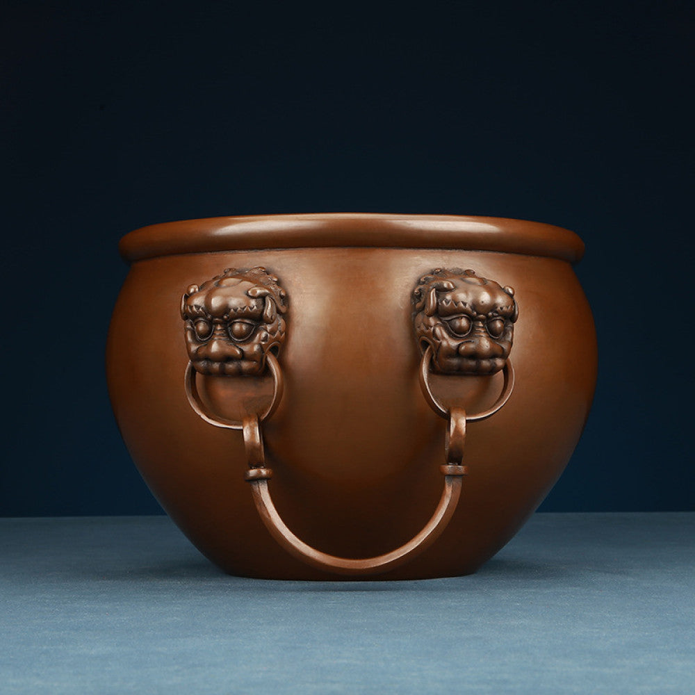 Polished bronze Chinese decorative vessel with intricate beast-head handles and hanging rings, a Feng Shui symbol of wealth and protection, displayed as elegant home decor against a white background 03