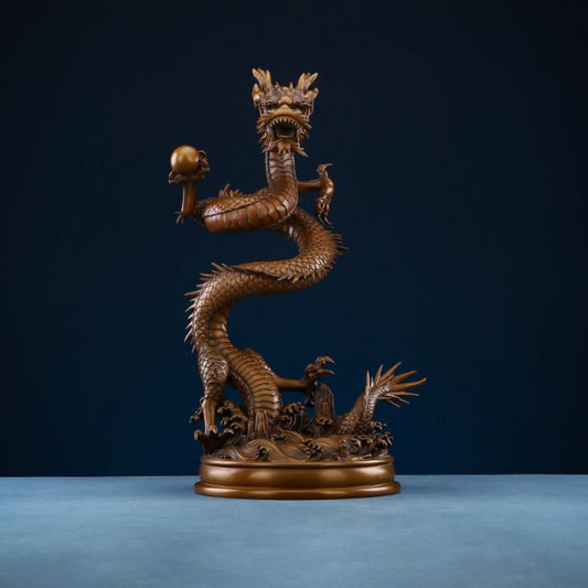 Intricate bronze Chinese dragon statue coiled around a pearl, a symbol of power and good fortune in Feng Shui, displayed on a blue surface against a dark blue background 01