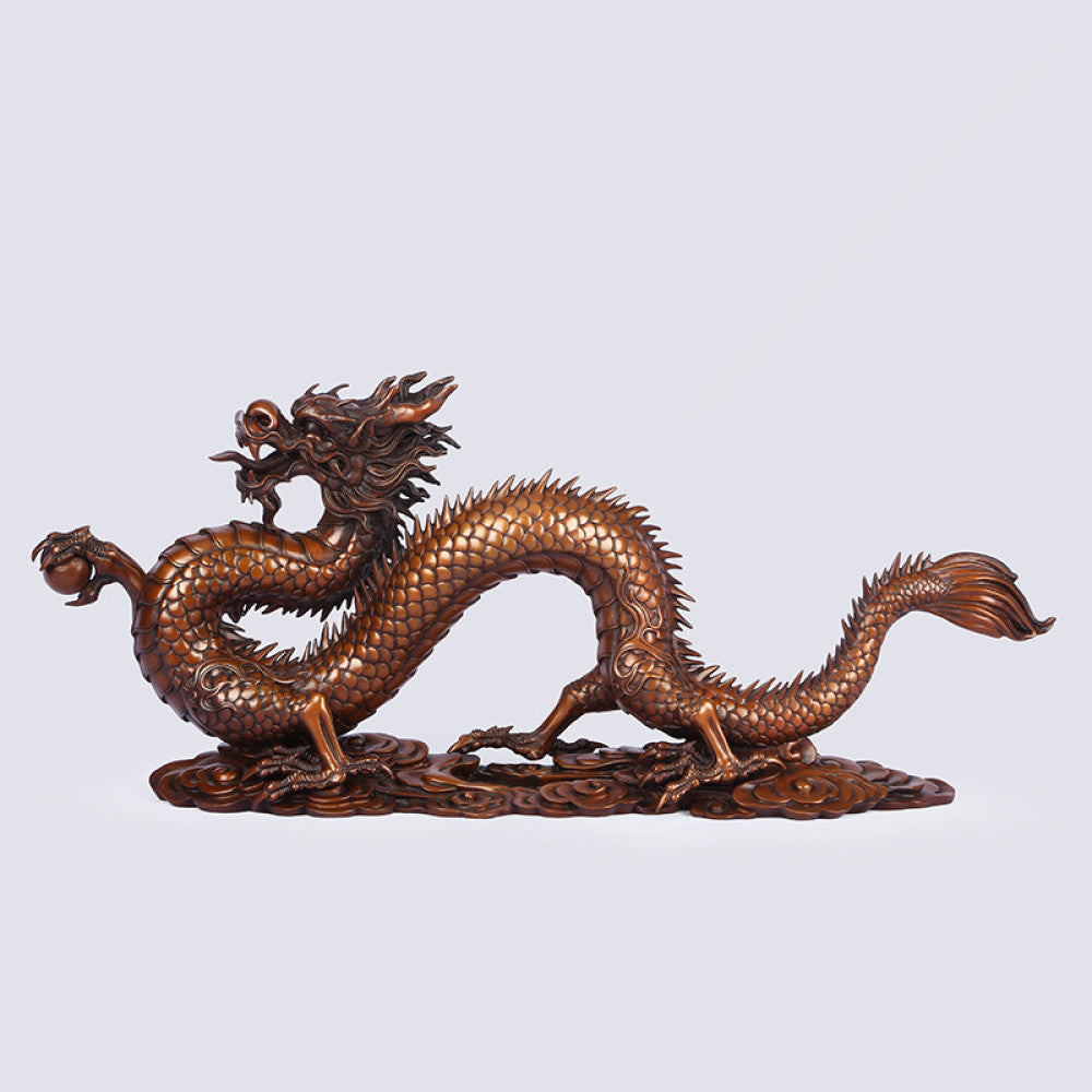 Bronze Chinese dragon statue with intricate scale details, a Feng Shui symbol of good fortune and strength, displayed as elegant home decor against a light background