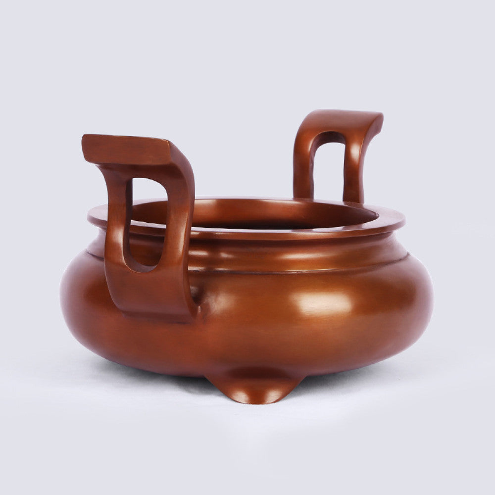 Polished bronze Chinese incense burner with elegant curved handles and three feet, a Feng Shui symbol of wealth and harmony, displayed as refined home decor against a white background 02