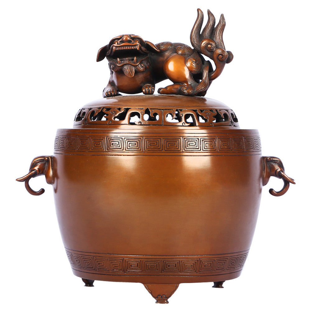 Intricate bronze Chinese incense burner with Foo Dog lid, elephant-head handles, and traditional geometric patterns, a Feng Shui symbol of wealth and protection, displayed as elegant home decor against a white background