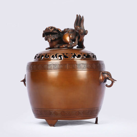 Intricate bronze Chinese incense burner with Foo Dog lid, elephant-head handles, and traditional geometric patterns, a Feng Shui symbol of wealth and protection, displayed as elegant home decor against a white background 01