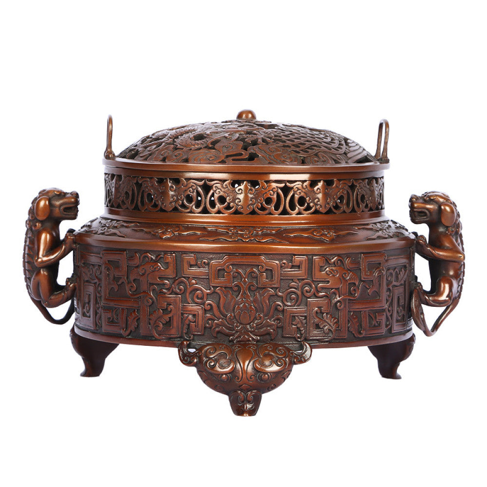 Intricate bronze Chinese incense burner with detailed beast handles, elaborate carvings, and a pierced lid, a Feng Shui symbol of wealth and harmony, displayed as elegant home decor against a white background
