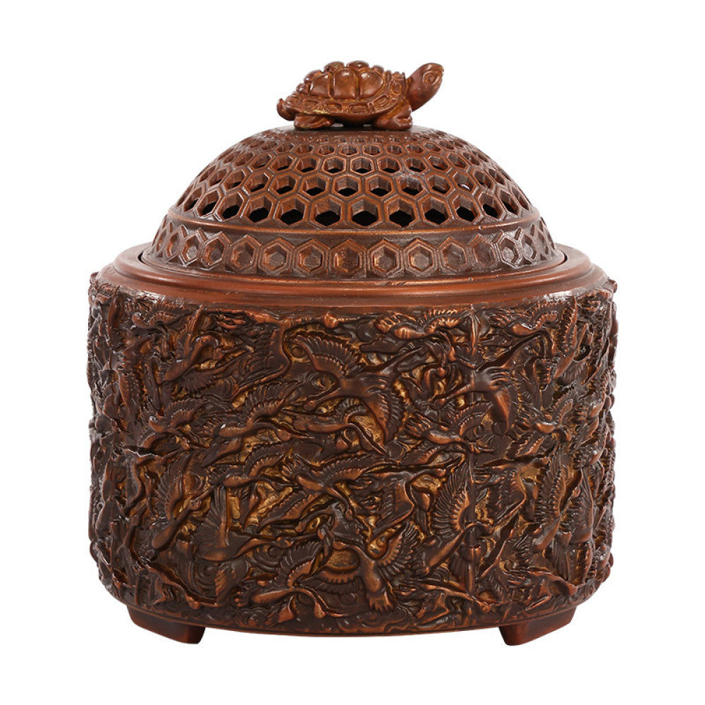Intricate bronze Chinese incense burner with a tortoise-topped pierced lid and elaborate crane carvings, a Feng Shui symbol of longevity and wealth, displayed as a unique home decor piece against a white background
