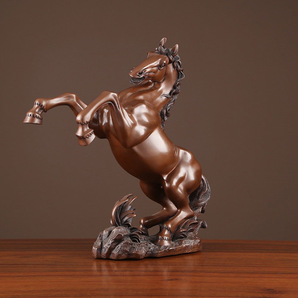 Bronze rearing horse statue with intricate details, symbolizing success and strength, displayed as elegant home decor on a wooden surface against a brown background