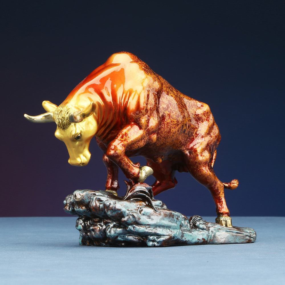 Colorful bull statue with golden accents, a Feng Shui symbol of strength and good fortune, displayed as elegant home decor against a dark background