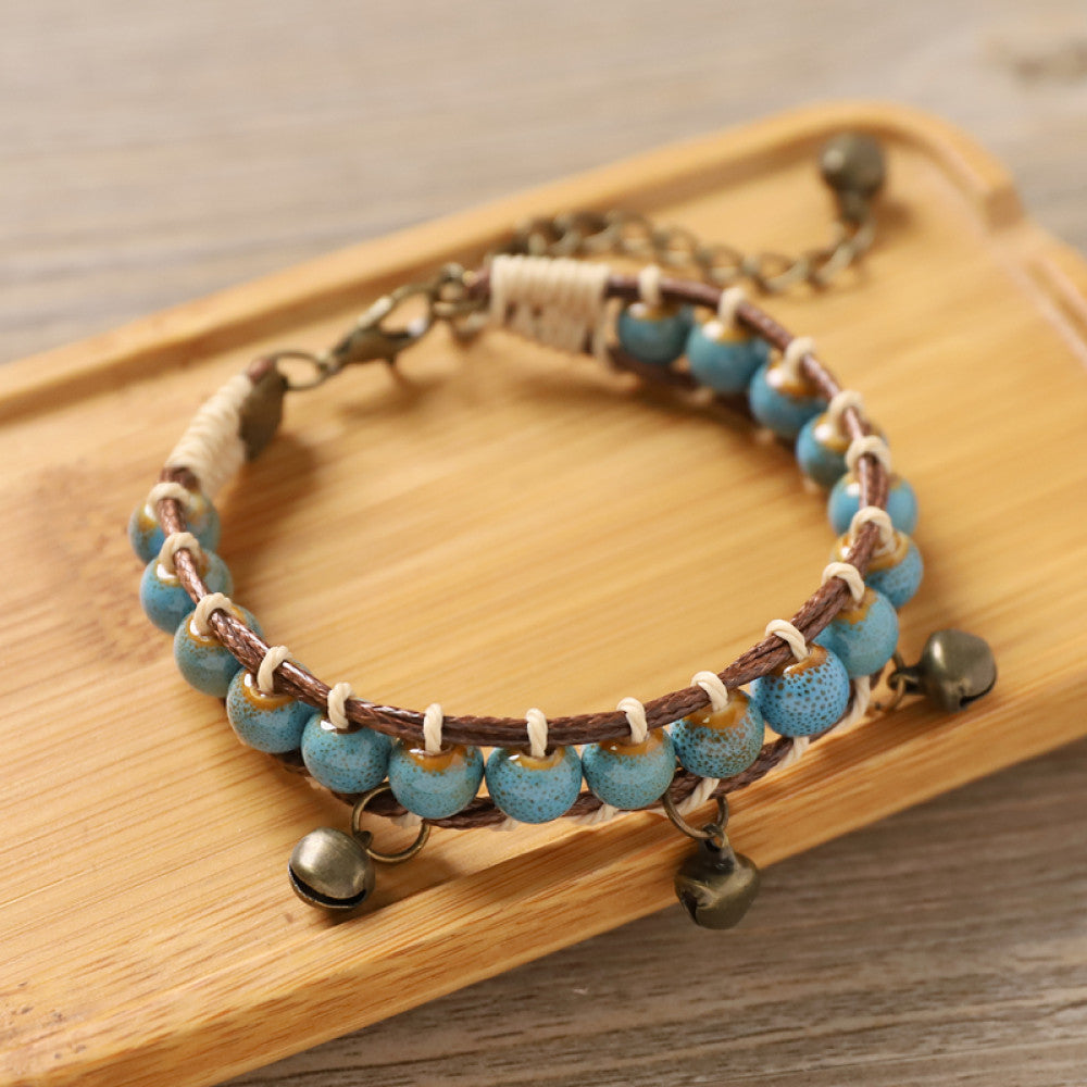 This bohemian bracelet features vibrant multicolored ceramic beads woven onto a brown leather cord