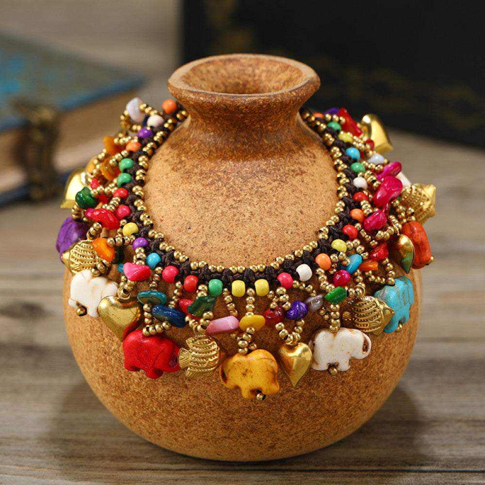 This vibrant multi-layered necklace features a rich mix of colorful beads and playful elephant charms in red