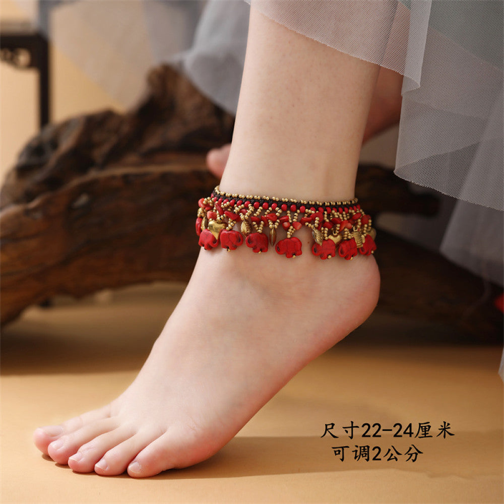 This vibrant multi-layered necklace features a rich mix of colorful beads and playful elephant charms in red, yellow, white, and turquoise, creating a bold ethnic-inspired statement. The intricate design adds a lively, bohemian touch to any outfit.