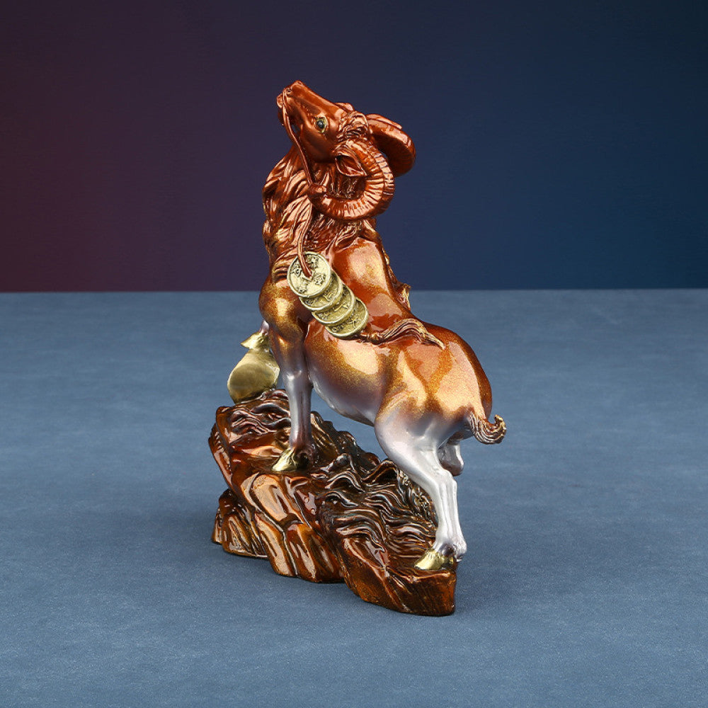 Colorful goat statue with golden details, a Feng Shui symbol of wealth and good fortune, displayed as elegant home decor on a textured base against a dark background