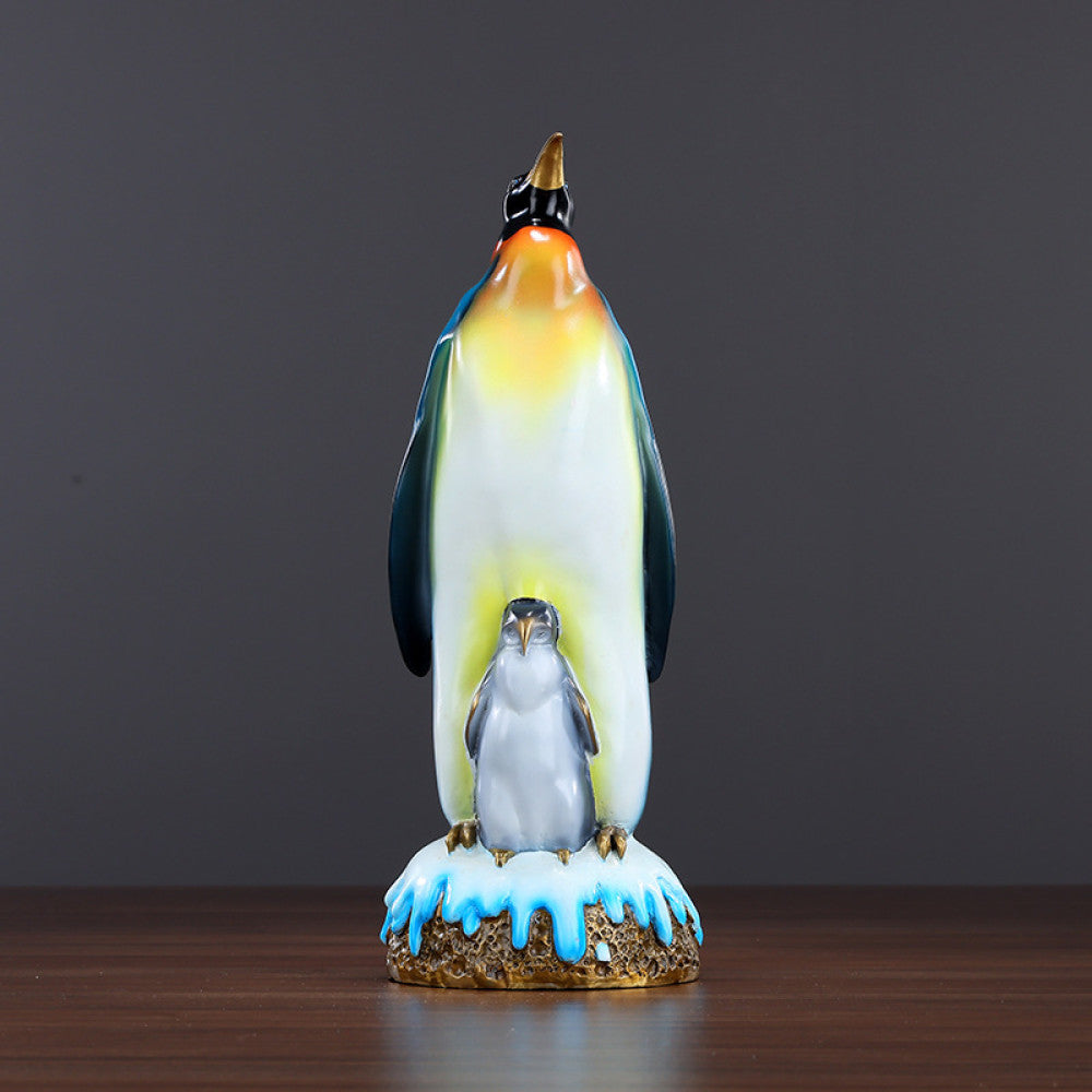 Colorful penguin statue featuring an adult penguin and a chick, designed as a charming home decor accent piece with a snow - themed base, displayed on a wooden surface against a gray background 02